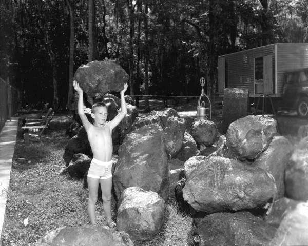 Unidentified boy holds up rocks that are movie props used in Around the World Under the Sea - Wakulla Springs, Florida.