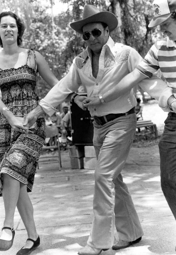 Secretary of State George Firestone (center), Florida Folklife Program director Phillip A. Werndli and Patti Schutt dancing with the Drava Folkdance Ensemble at the 1980 Florida Folk Festival - White Springs, Florida