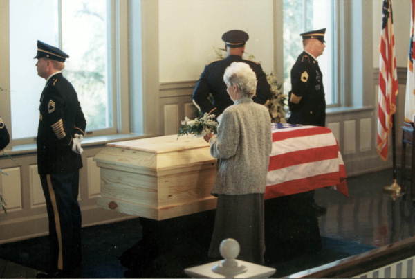 Rhea Chiles placing white flowers on Governor Chiles' casket