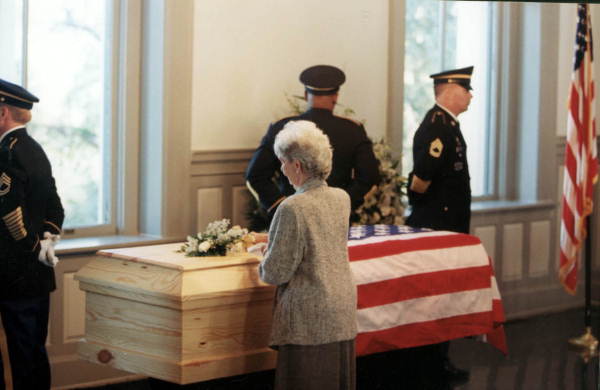 Rhea Chiles placing white flowers on Governor Chiles' casket