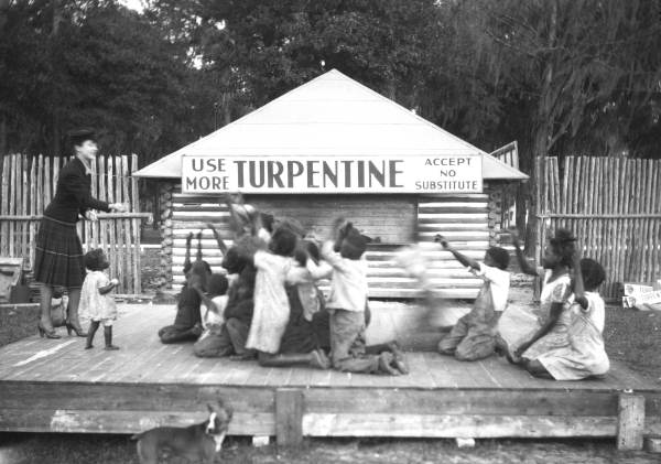 Woman and children on stage at turpentine plant in Brooksville, Florida.