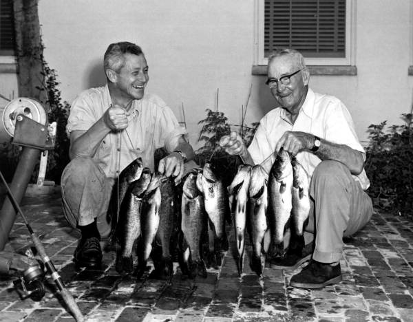 Governor LeRoy Collins helping his father hold up their catch of black bass - Tallahassee, Florida