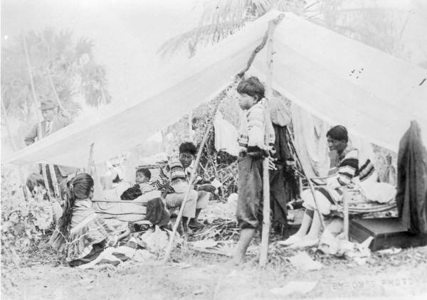 Seminole Indians under canvas shelter