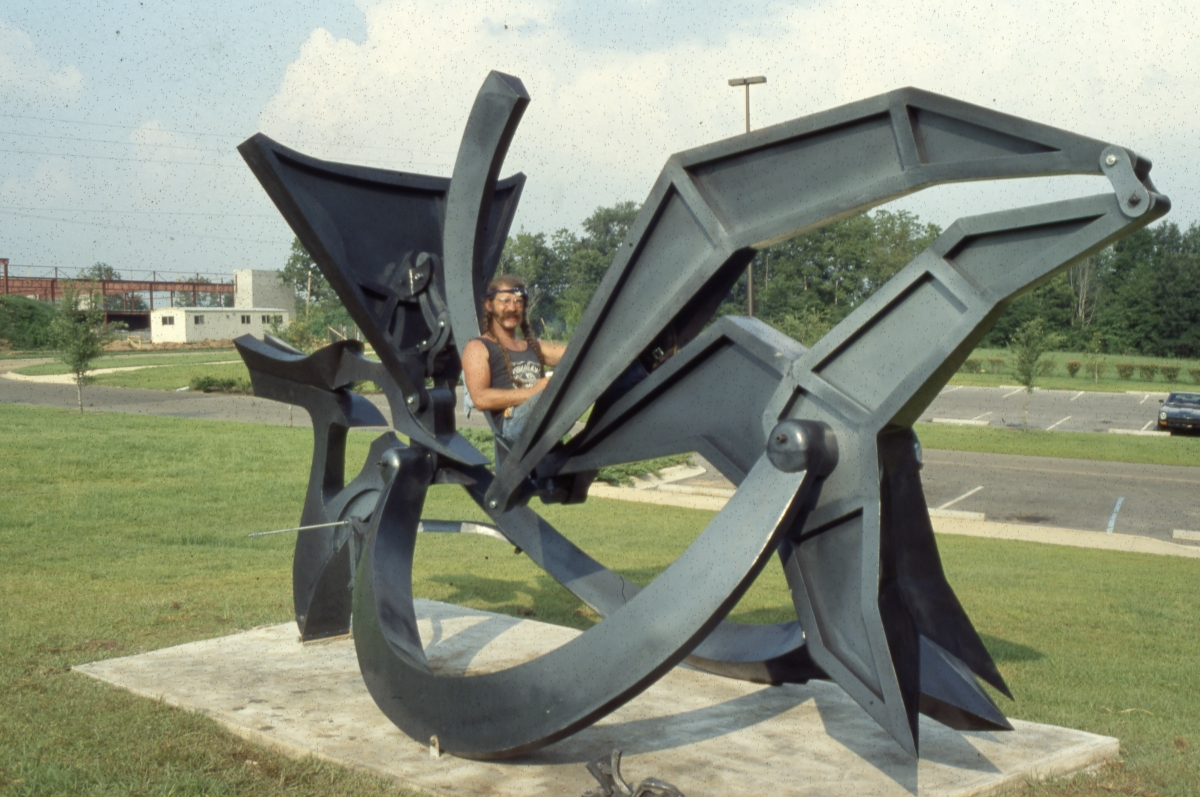 Charles Hook sitting on his fully installed "Big Bend II" sculpture at Innovation Park in Tallahassee.