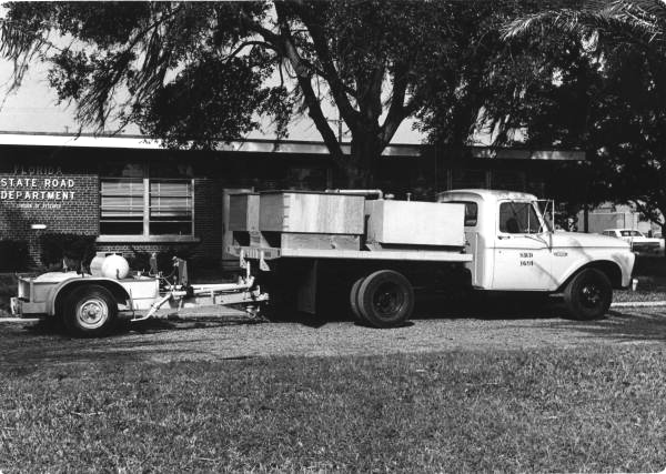 Truck and trailer in front of State Road Department .