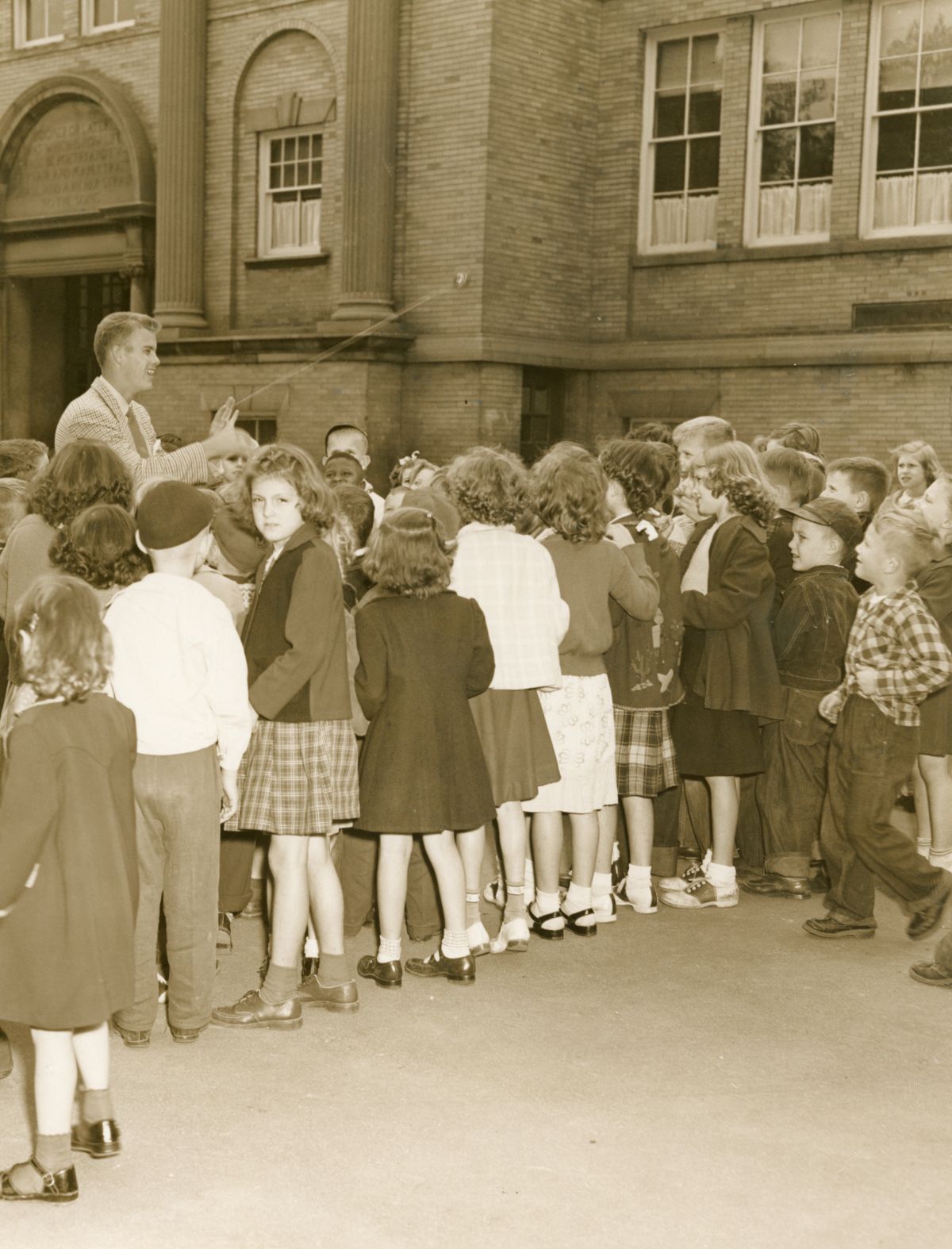 Man with yo-yo amusing children during tour of the Florida Industrial School for Boys in Marianna, Florida.