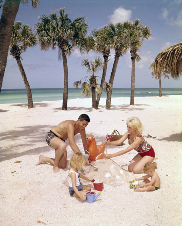 Family building a sandcastle at the beach in Sarasota, Florida.