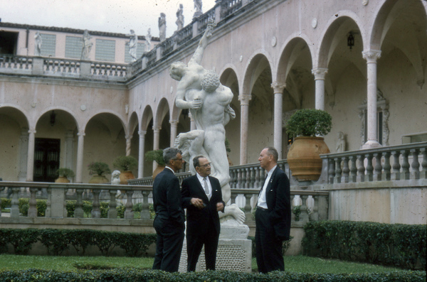 Dominican Republic ambassador Jose A. Bonilla Atiles speaking with men in the courtyard at the John and Mable Ringling Museum of Art in Sarasota, Florida.