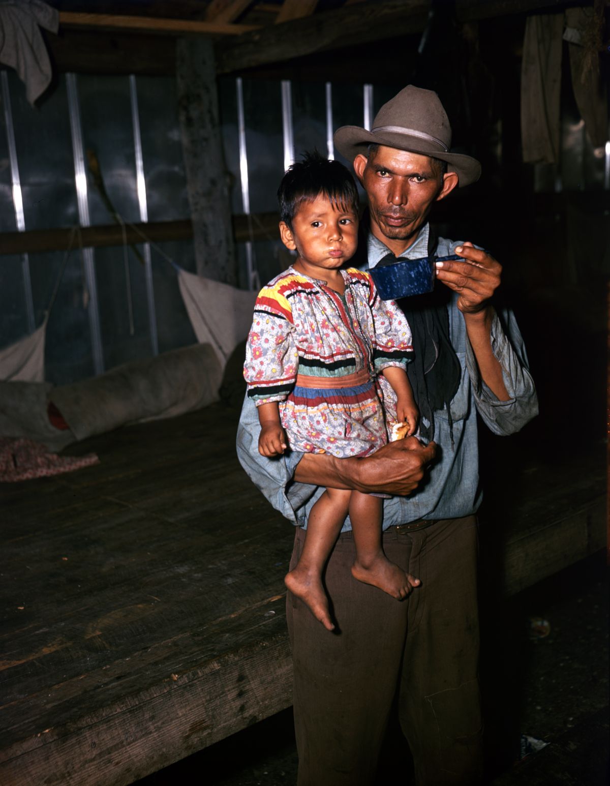 Seminole father giving his child some soup at a barbeque during the annual cattle round-up at the Big Cypress Seminole Indian Reservation.