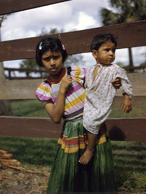 Portrait of Seminole girl holding her baby brother at the Brighton Indian Reservation.