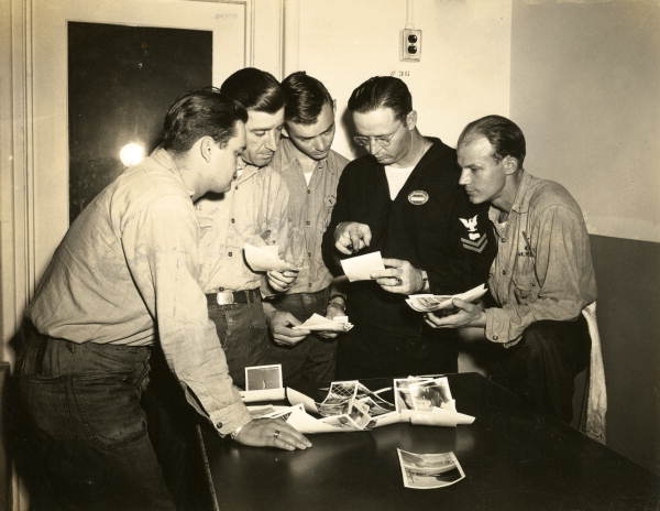 Naval Photography School instructor viewing photographic prints with students at NAS Pensacola.