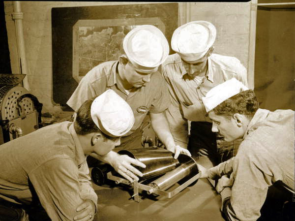 Naval Photography School instructor showing students how to put film on the spool at NAS Pensacola.