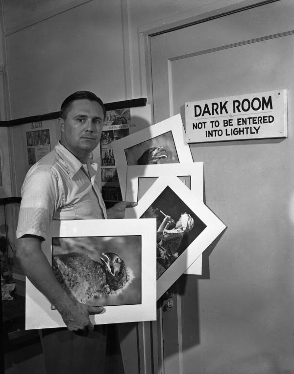 Joe Steinmetz with photographs at the entrance to the darkroom at his studio in Sarasota, Florida.