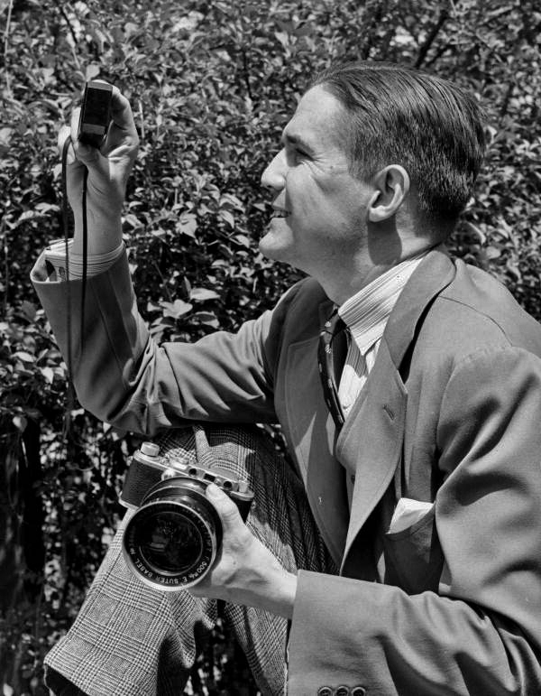 Portrait of Sarasota photographer Joe Steinmetz with his camera and light meter.