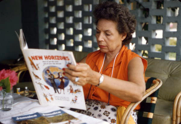 Photographer's wife, Lois Foley Steinmetz, reading a copy of New Horizons in Nassau, Bahamas.