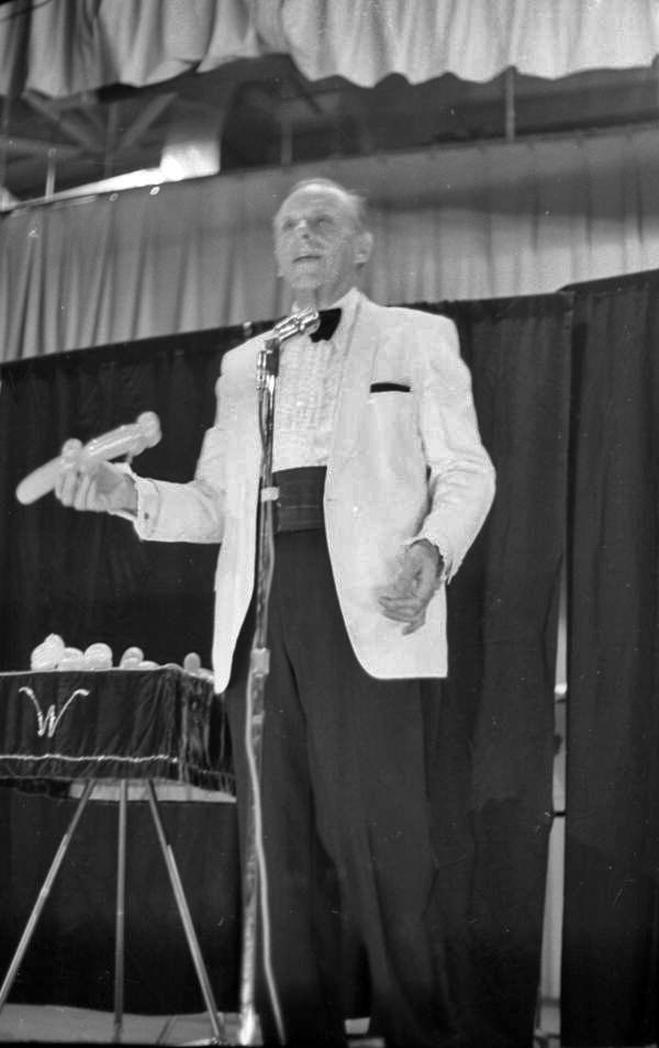 Magician on stage with a twisted balloon during a magic show at the Sarasota Jr. High School.