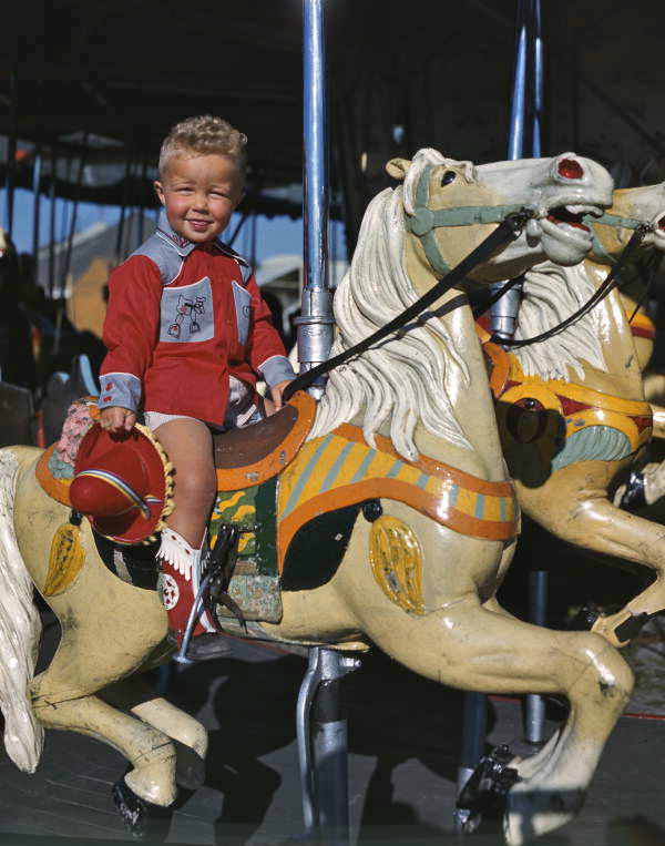 Boy on a merry-go-round in Taos, New Mexico.