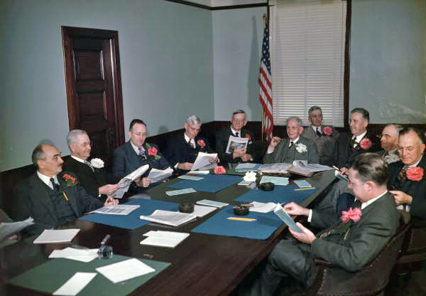 Business meeting with all men wearing azaleas in their lapels.