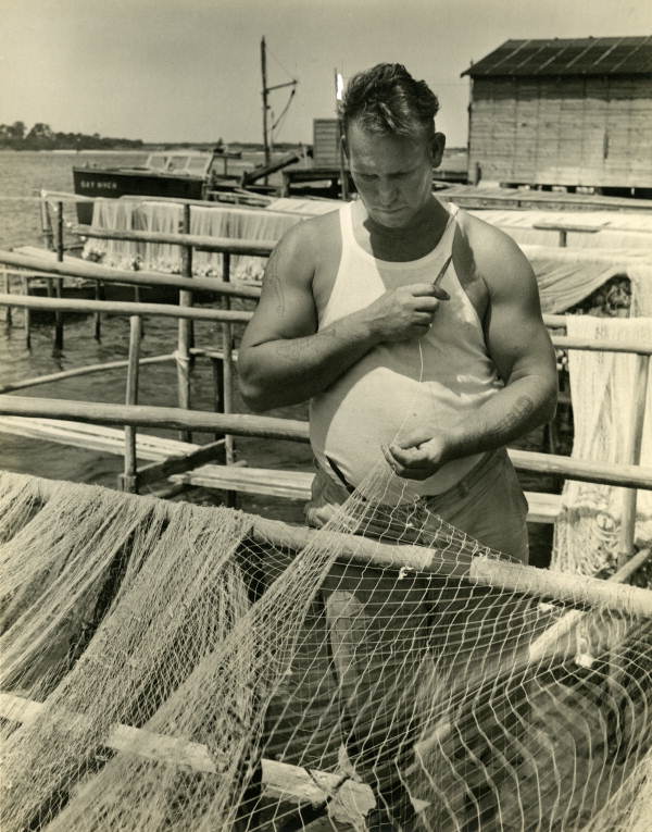 Unidentified man mending fishing nets in the Sarasota area.