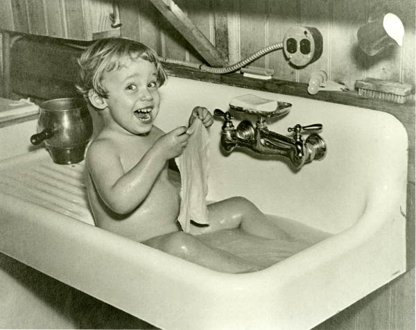Photographer's daughter Lois Duncan having a bath in the sink.
