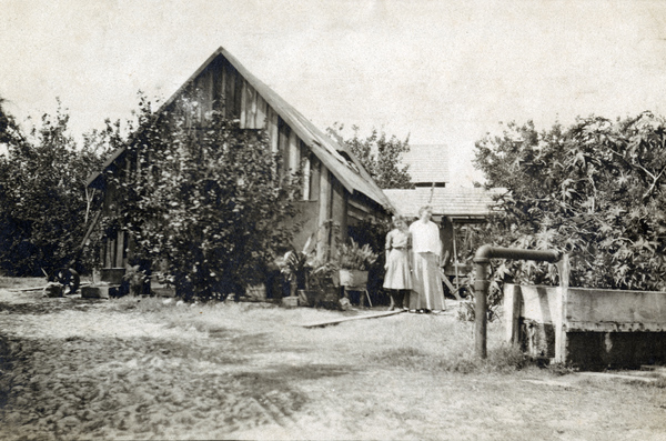 Koreshans standing next to a pioneer house in Estero, Florida.