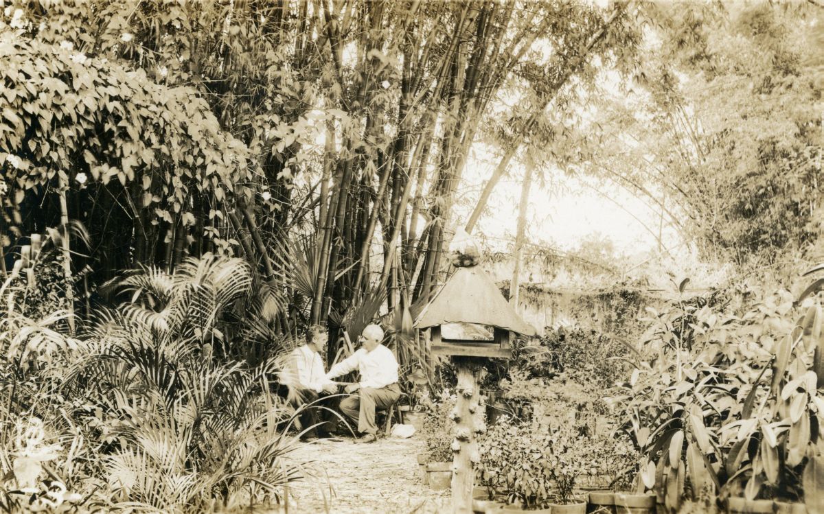 Postcard showing Koreshan president Allen Andrews sitting with Raymond Pilgrim at Bamboo Landing in Estero, Florida.