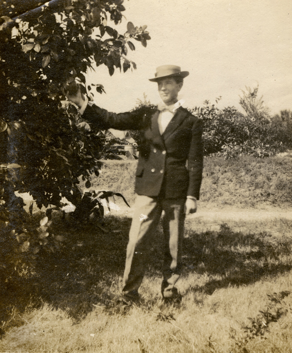 Portrait of Koreshan Lloyd Graham standing next to a citrus tree.