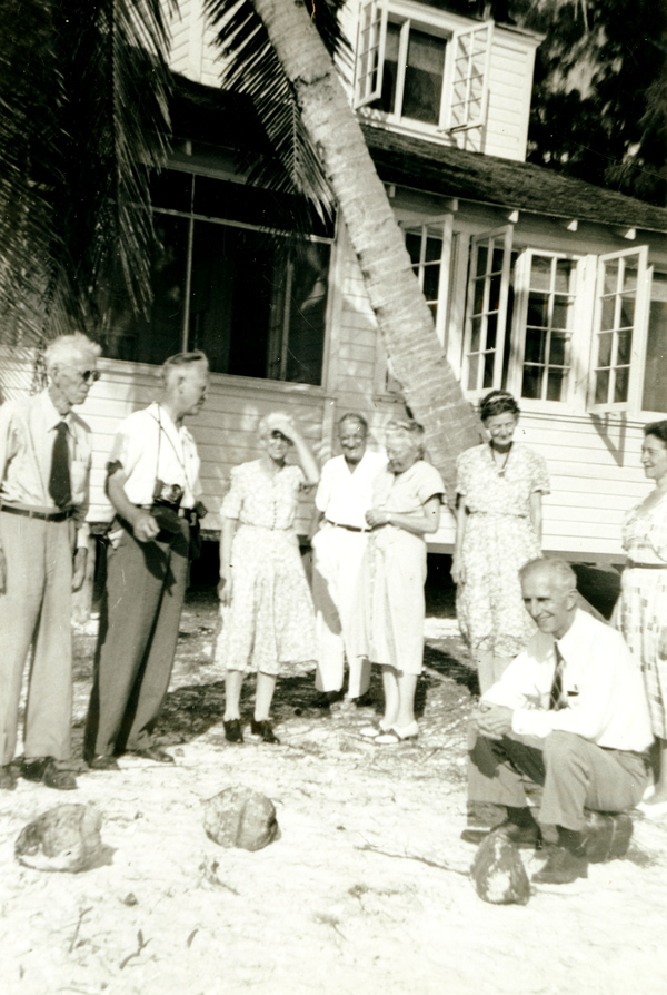 Koreshans looking at coconuts next to the Koreshan Unity's "Rising Tide Cottage" at Fort Myers Beach, Florida.