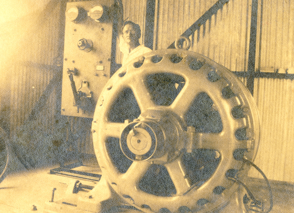 Alfred Christensen standing next to new motor and switchboard inside power plant at the Koreshan Unity in Estero, Florida.