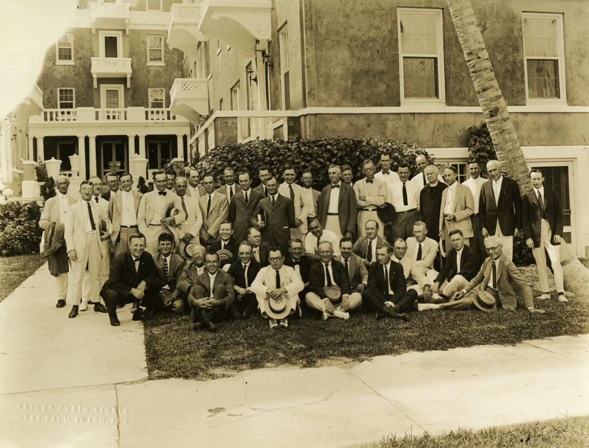 Group portrait of Rotarians in front of the Lake Court Apartments.