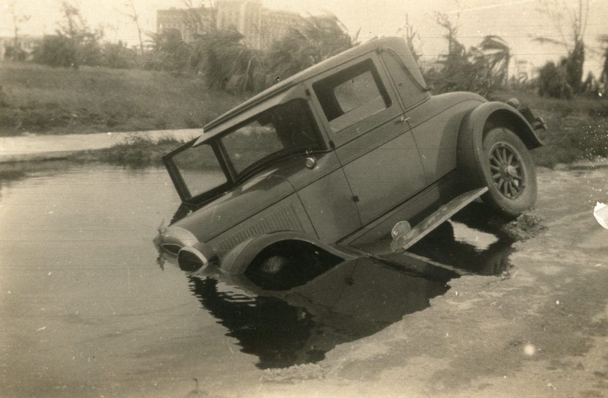 Car blown into damaged road during the 1926 hurricane in Miami Beach.