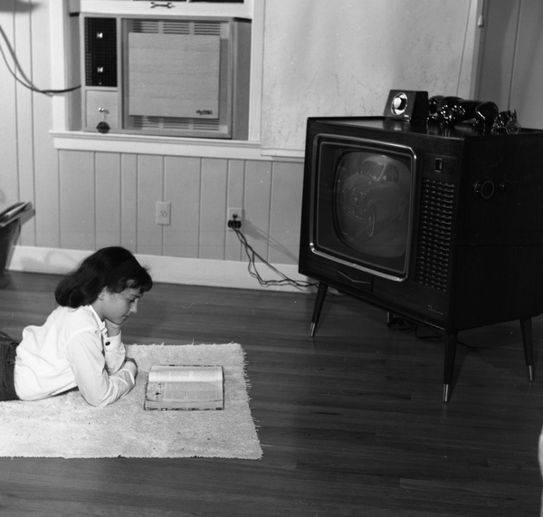 Tallahassee teen reading in front of the t.v.