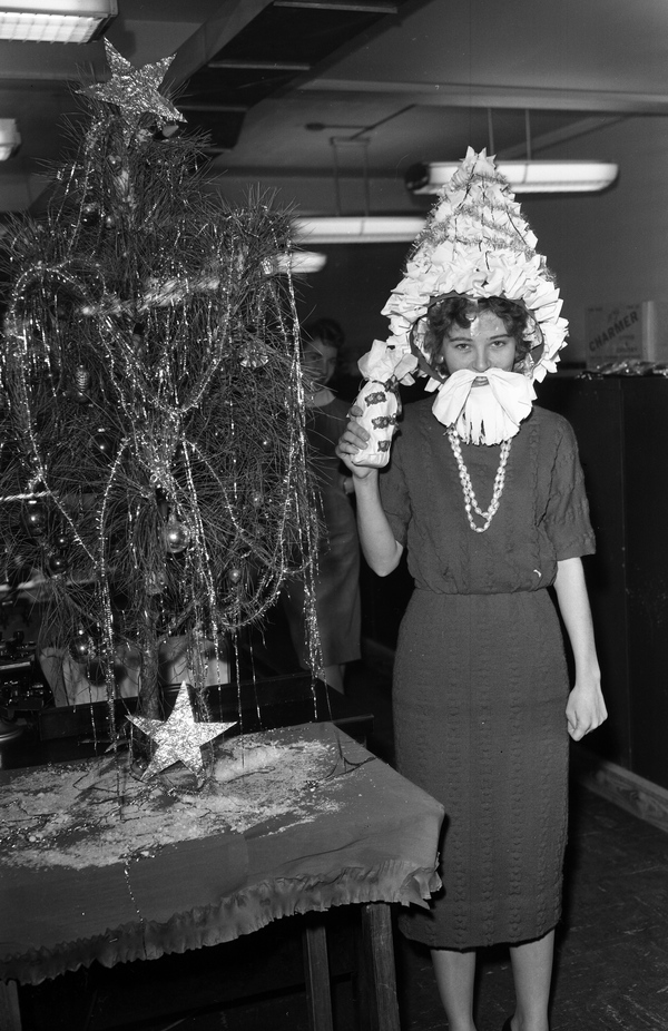 Woman in costume standing next to a Christmas tree in Tallahassee.