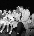 FSU's head football coach Bill Peterson sitting on sideline with Rec. Dept. players in Tallahassee.