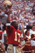 FSU quarterback Charlie Ward holding up his helmet on the sideline during a home game in Tallahassee, Florida.