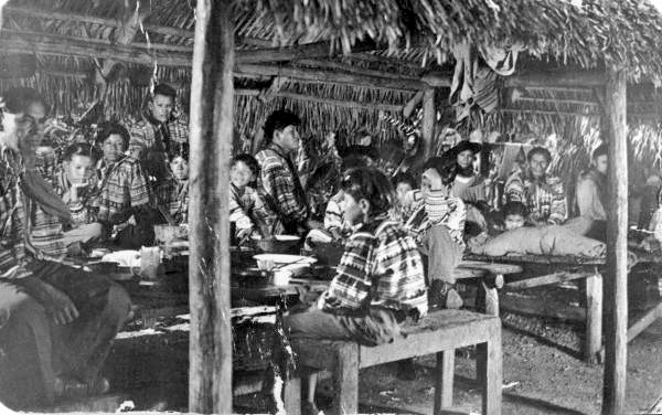 Seminole Indians gathered under a chickee