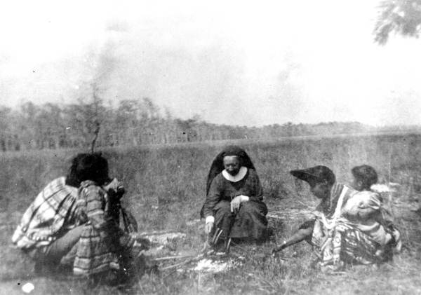 Deaconess Bedell and Seminole Indians roasting wieners