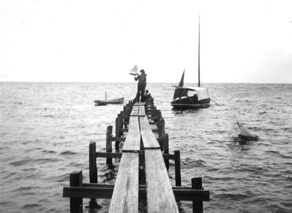Boys with toy boat on J.C. Williams' dock.
