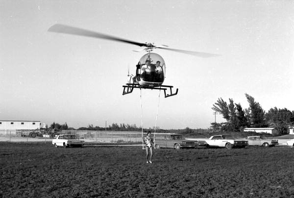Circus girl riding beneath helicopter - Key West, Florida.