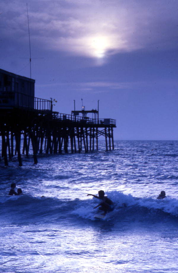 View showing people surfing next to the Canaveral Pier in Cocoa Beach, Florida.
