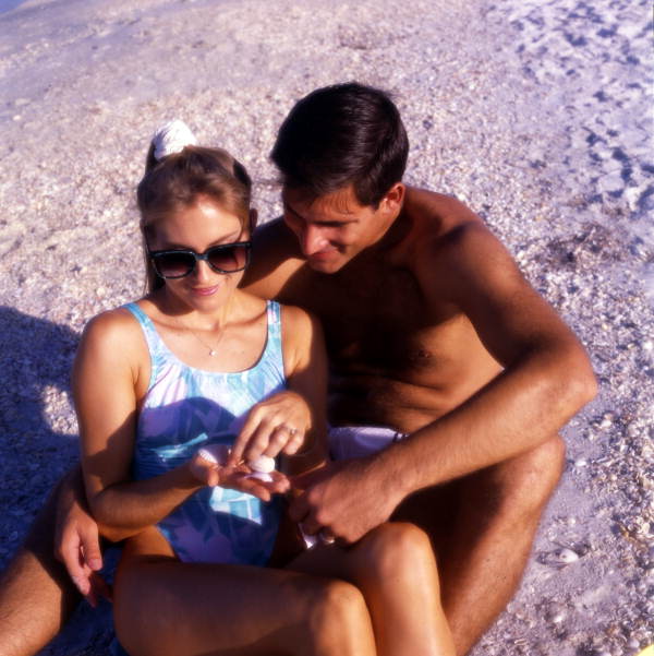 Couple looking at seashells at the beach on Sanibel Island, Florida.