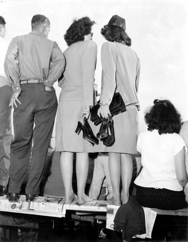 Two women stand on top of the bleacher in order to see the race - Daytona Beach, Florida