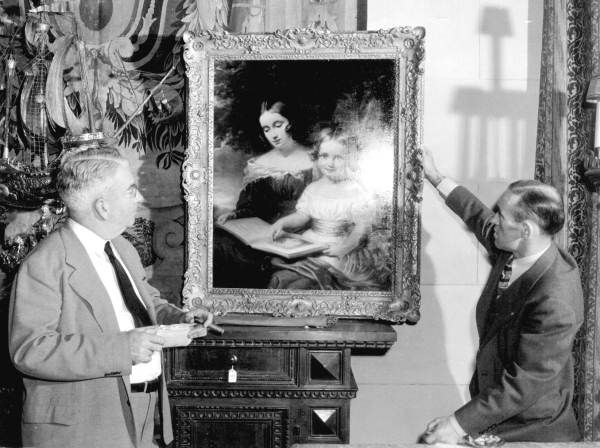 Auctioneers display a painting during the Stotesbury estate auction - Palm Beach, Florida.