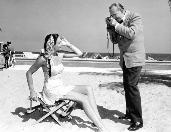 Photographer Dean Cornwell photographs Mrs. Hjordis Termesden on the beach - Palm Beach, Florida.