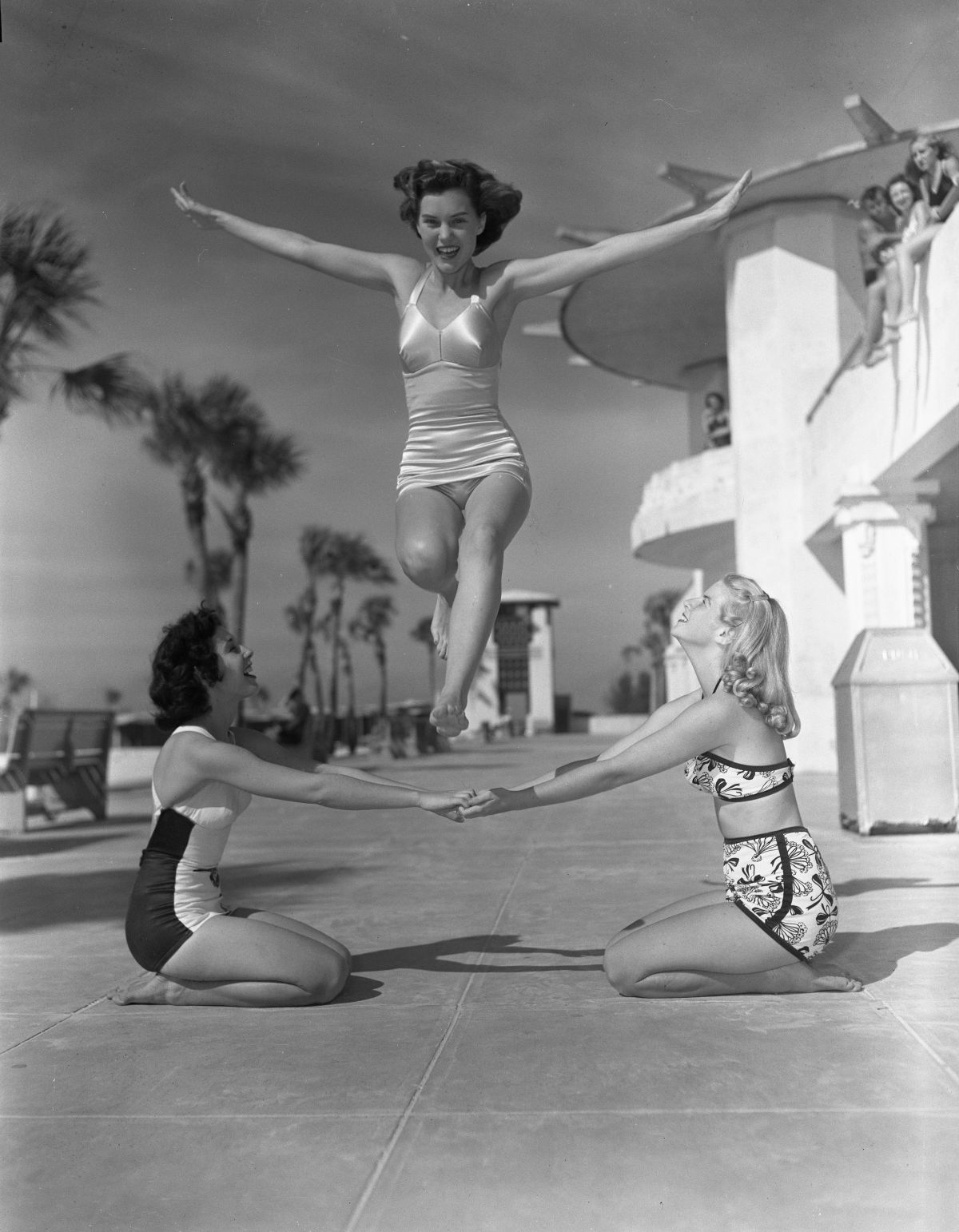 Three young women pose for jumps on the sidewalk at Lido Beach - Sarasota, Florida.