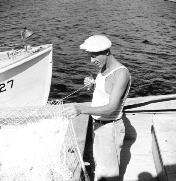 Commercial fisherman Malcolm Butler mending a mullet fishing net - Tarpon Springs, Florida