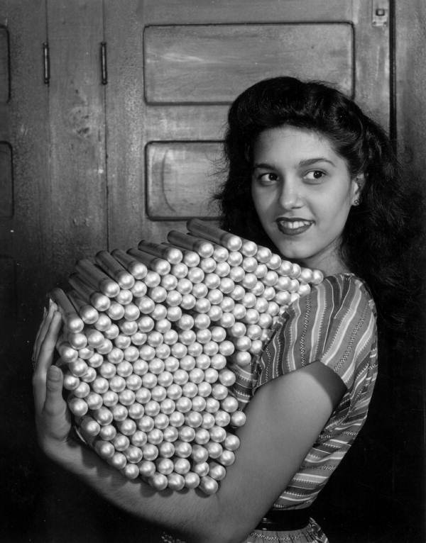 Olga Cabrera holds an armload of aluminum tubes for filling with hand rolled cigars - Tampa, Florida.