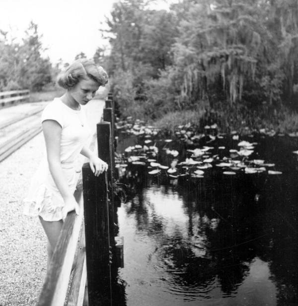 Martha Green looks over the bridge into the water - Sebring, Florida .