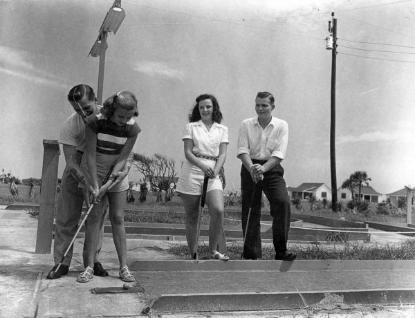 Four people play miniature golf - Saint Augustine, Florida.