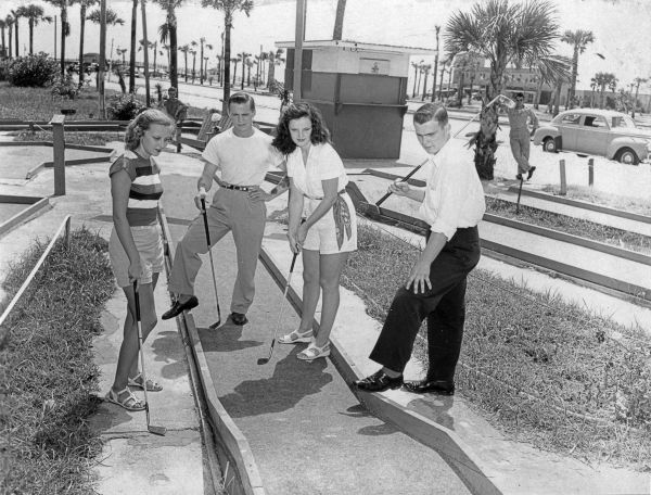 Four people play miniature golf - Saint Augustine, Florida.